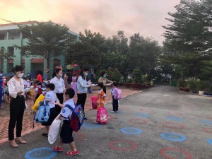 Sát khuẩn, đo thân nhiệt cho các em học sinh trước khi vào lớp học